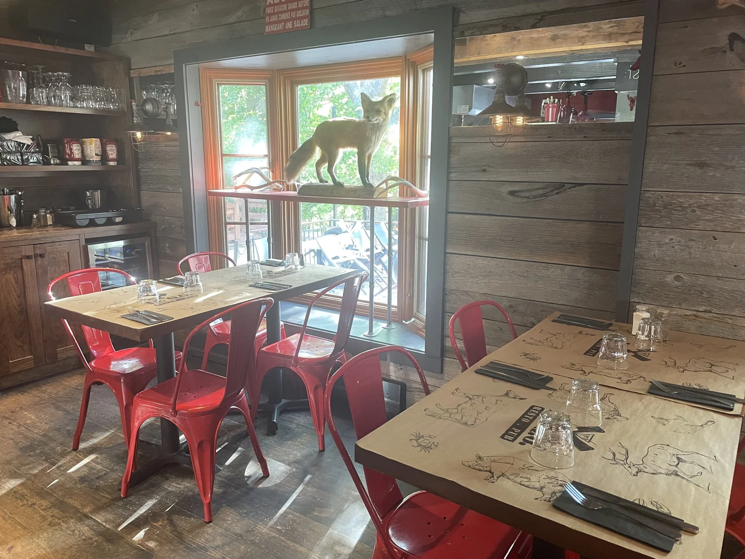 Salle à manger Le Q.G. avec chaises rouges et taxidermie